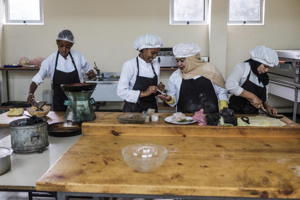 اللاجئة اليمنية حنان وصديقتها الإثيوبية يانشينيو (في الوسط) تعدان الطعام كجزء من دورة للطهي في كلية نيفاس سيلك للفنون التطبيقية في أديس أبابا، إثيوبيا.