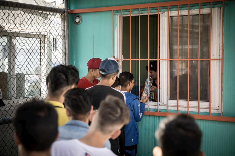 Menores no acompañados de Afganistán y Siria hacen fila para comer en la Sección A del centro de recepción de Moria. 