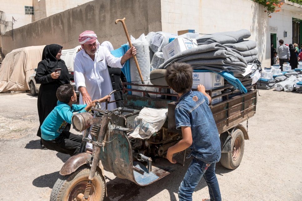 Une famille de déplacés internes syriens aidée par le HCR à retourner dans sa maison pillée dans les campagnes proches d'Alep, juillet 2018. 