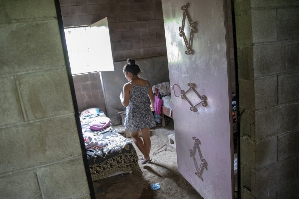 Verónica*, una joven desplazada internamente por la violencia en El Salvador, camina dentro de su casa, en una comunidad que la ha acogido. Las personas desplazadas por la violencia tienen necesidades apremiantes de acceso a vivienda, al ser forzadas a abandonar sus hogares para salvar sus vidas.