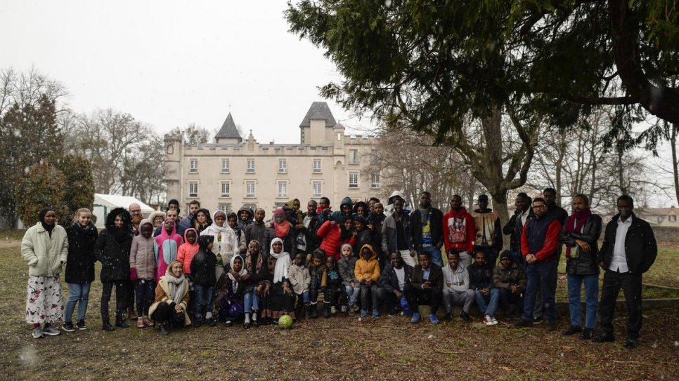 Refugees and members of the Cécler Association gather in front of the City Hall.