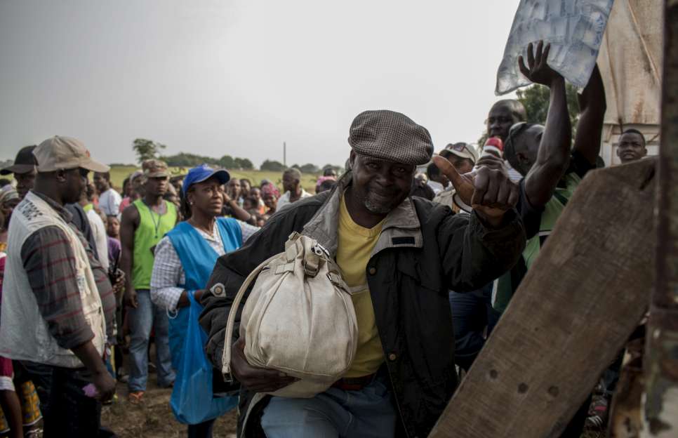 Nicolas, 52, shows a sign of appreciation to his friends and neighbours before climbing into the truck to meet his family. "Some of our neighbors will stay here, and they tell me if I'm not scared of returning. But for me it's a joy for us to have the opportunity to return." 11,000 out of the 38,000 Ivorian refugees living in Liberia's three refugee camps have expressed their willingness to return home immediately.