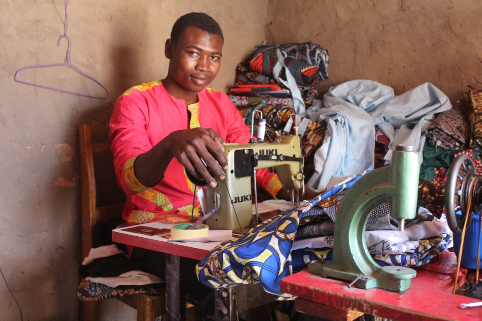 Saladine confectionne une robe dans son atelier au camp de Doholo, au Tchad, où il emploie, à son compte, trois autres réfugiés.   