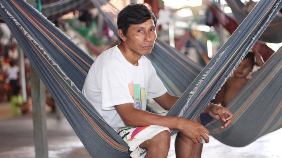 Warao community leader Eligio Tejerina, 33, sits in a hammock next to his children at Pintolandia Shelter in Boa Vista, northern Brazil. 