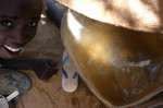 A refugee boy with untreated water collected from a local well in the border town of Bahai. UNHCR relocated refugees from the Bahai area to a camp at Oure Cassoni where safer, treated water is provided. (July 4, 2004)