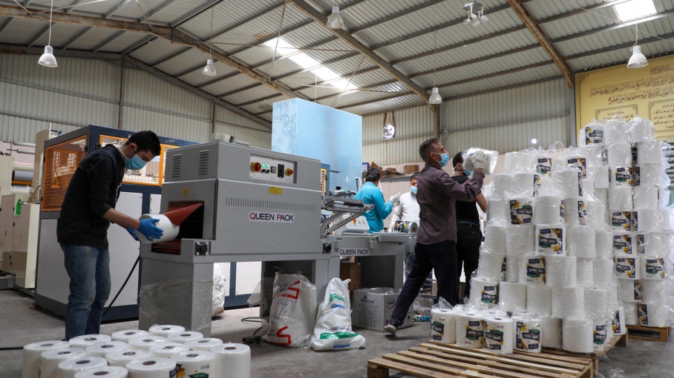 Employees, including Syrian refugees, pack tissues at Al Khamael factory in the Sahab suburb of Amman, Jordan.