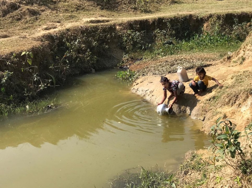 Des enfants réfugiés rohingyas puisent de l'eau dans une mare pour la préparation des repas et la toilette en raison de ressources en eau potable limitées dans l'installation de réfugiés de Nayapara, au Bangladesh. Janvier 2018.  