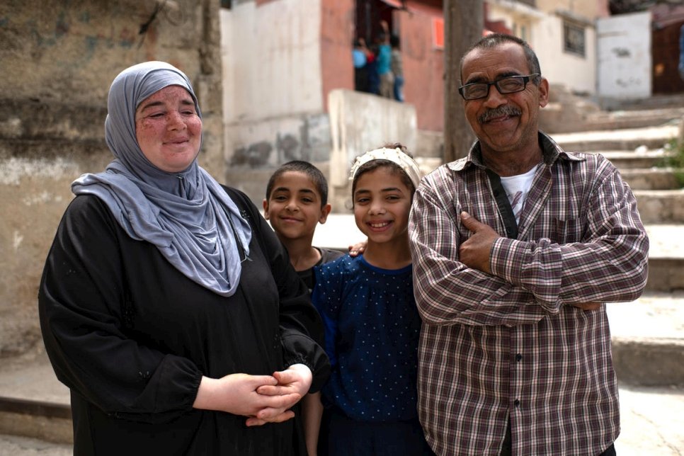 Les réfugiés syriens Mustafa et Sherin se tiennent devant leur maison à Amman avec deux de leurs enfants, Nadia, 12 ans, et Muhammad, 10 ans, pendant le confinement pour enrayer la pandémie de Covid-19. Ils ont fui Damas en 2013. 