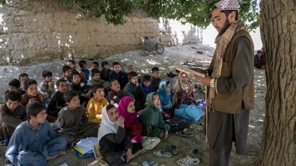 Pupils sit beneath the shade of mulberry trees in the village of Qarabagh.