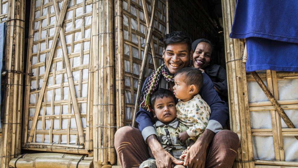 Abul Kalam holds his sons Mohammad Arafat and Mohammad Ayaz in Camp 1 West, Kutupalong. Cox's Bazar, Bangladesh.