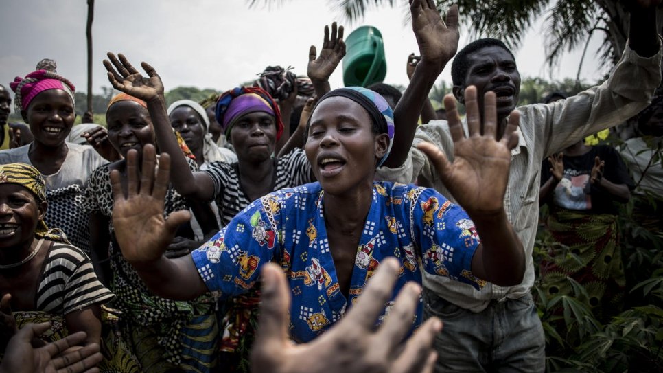 Claudine Nyanzira, a 29-year-old Burundian refugee who is six months pregnant and a beneficiary of Evariste Mfaume's agricultural project, sings and dances at Lusenda refugee camp.
