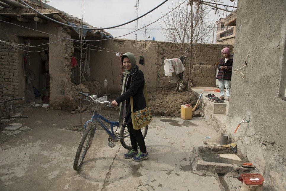 العائدة الأفغانية كوبرا يوسفي تفحص دراجتها قبل أن تغادر إلى صفها الدراسي في كابول، أفغانستان.