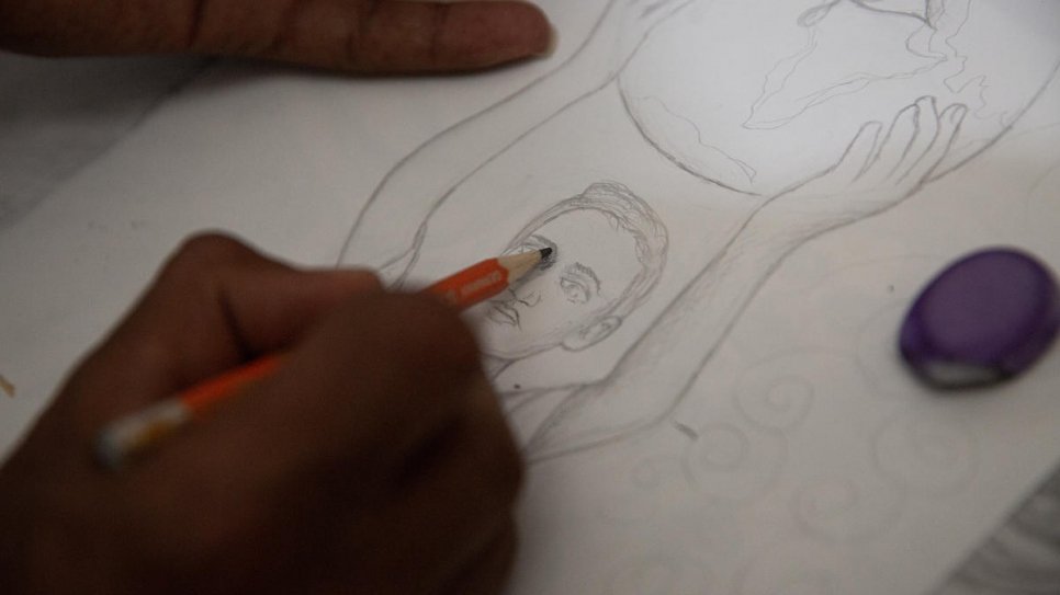 Solomon, who has no formal art training, sketches a new design in pencil.
