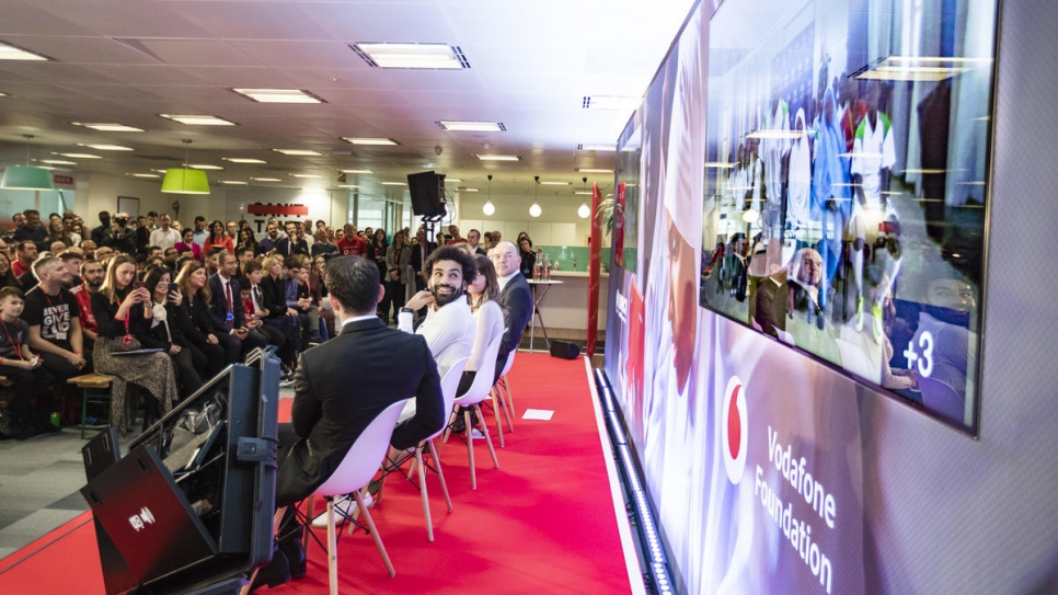 Football star Mohamed Salah glances at a TV screen at an event in London during which he was announced as the first Ambassador of Instant Network Schools.