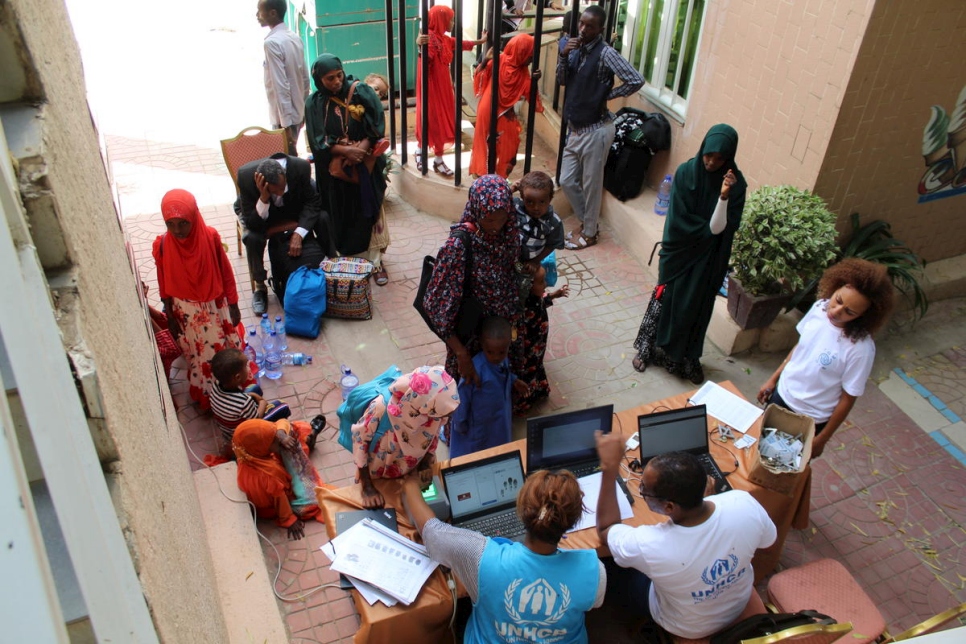 Some of the newly arrived returnees assemble at a registration desk in Dire Dawa, Ethiopia, to have their details taken.