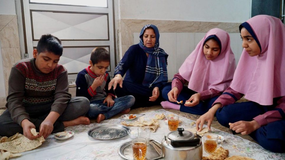 Afghan refugee Halime (centre) prepares breakfast for two of her sons and her daughters Parisa, 16, and Parimah, 14, at home in Esfahan, central Iran.