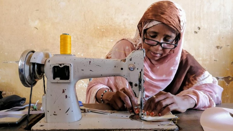 Fatouma, a refugee from Mali, uses a sewing machine to make face masks at a workshop in Niamey.