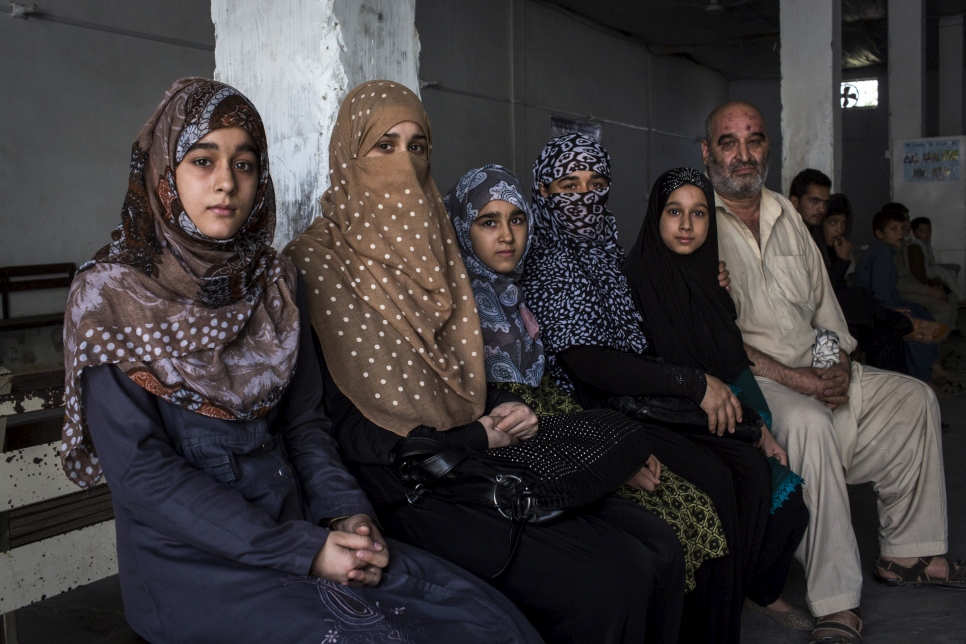 Shazia Razi (deuxième à partir de la gauche), Abdul Razi (à droite) et leurs quatre enfants attendent dans un centre de rapatriement volontaire du HCR à Peshawar, au Pakistan. Après des décennies d'exil, ils préparent leur rapatriement en Afghanistan. 