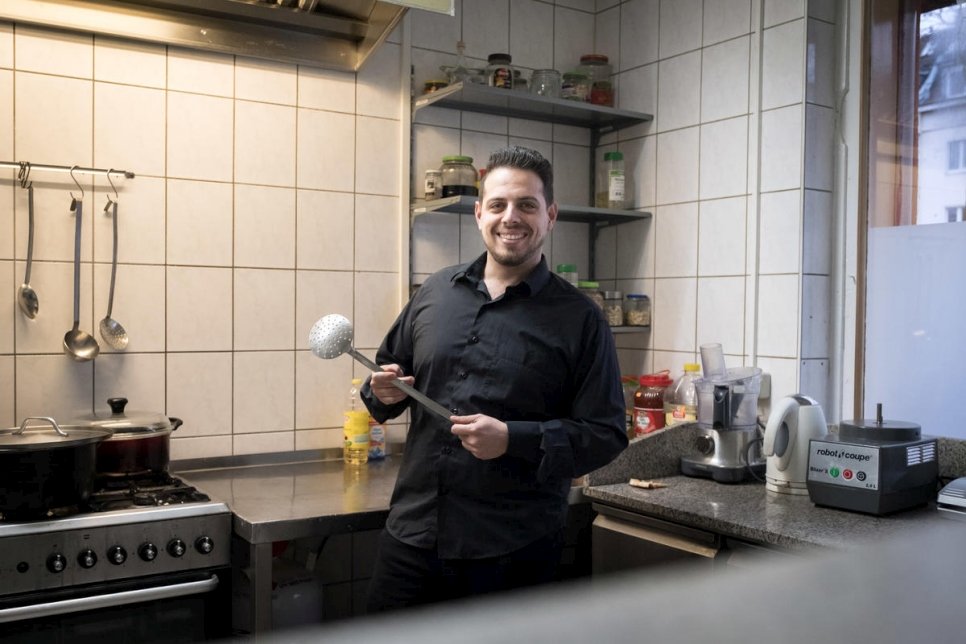 اللاجئ السوري فادي الزعيم في مطبخ والدته سلمى العرمشي في برلين، حيث تدير شركتها "ياسمين للضيافة".