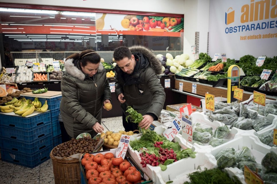 اللاجئة السورية سلمى العرمشي وابنها فادي الزعيم، يشتريان المواد الغذائية الطازجة في سوبر ماركت تركي بالقرب من مطبخ الشركة في برلين. 

