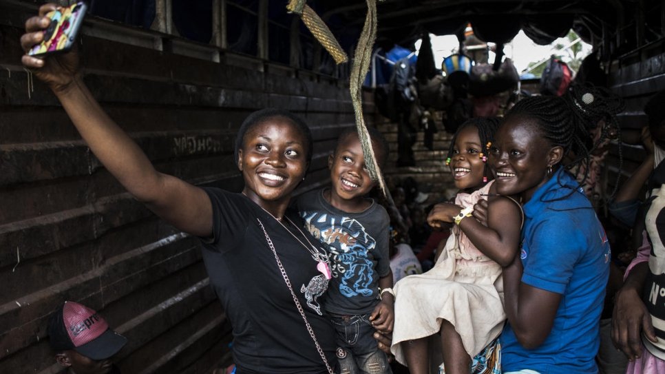 Des rapatriés congolais prennent des selfies lors de leur rapatriement depuis l'Angola vers Kananga, dans la province du Kasaï de la République démocratique du Congo. 