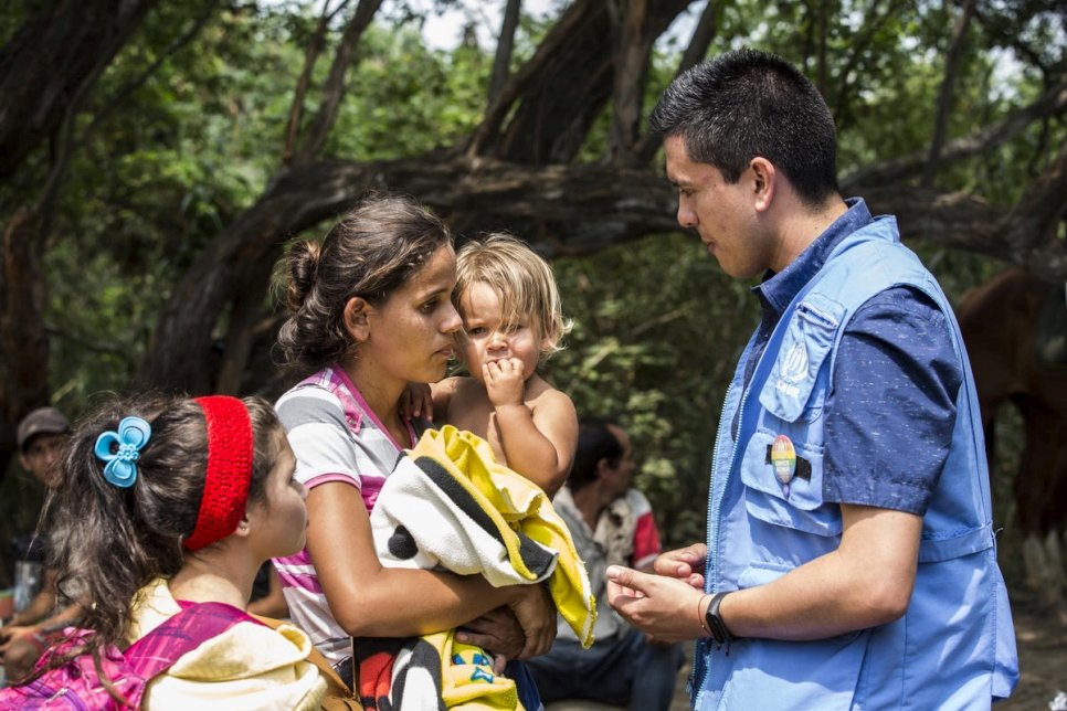 Une ressortissante vénézuélienne accompagnée de ses enfants s'entretient avec un employé du HCR en charge de la protection après avoir traversé la frontière vers Cucuta en Colombie. 