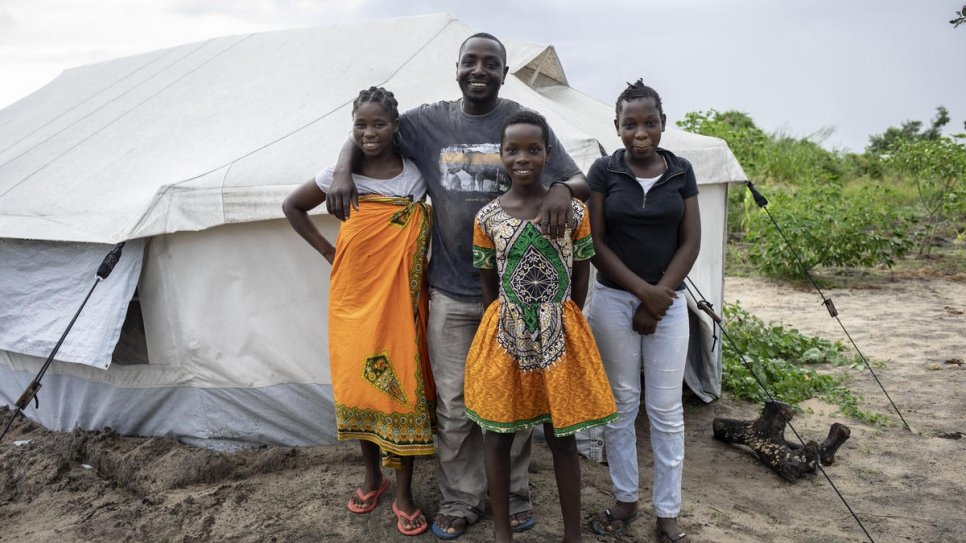 Jose Martinho, 43, poses with his wife Angelina, 31, and their daughters Laura, 12, and Luiza, 14, in front of their tent in Mutua settlement, which hosts some 700 people. They were relocated there after Cyclone Idai a year ago.