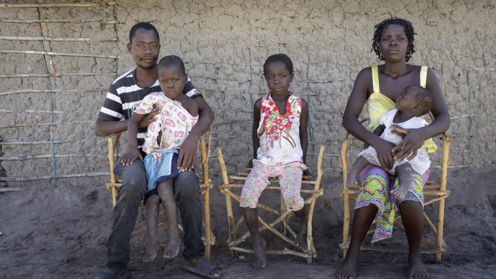 Amelia, her husband Almeida Juoa, 34, and their children Rosa, 8, Elias, 4 and Alsofina, who is one year old, pose in front of their home in Savane settlement. They were relocated there by the government after Cyclone Idai a year ago.