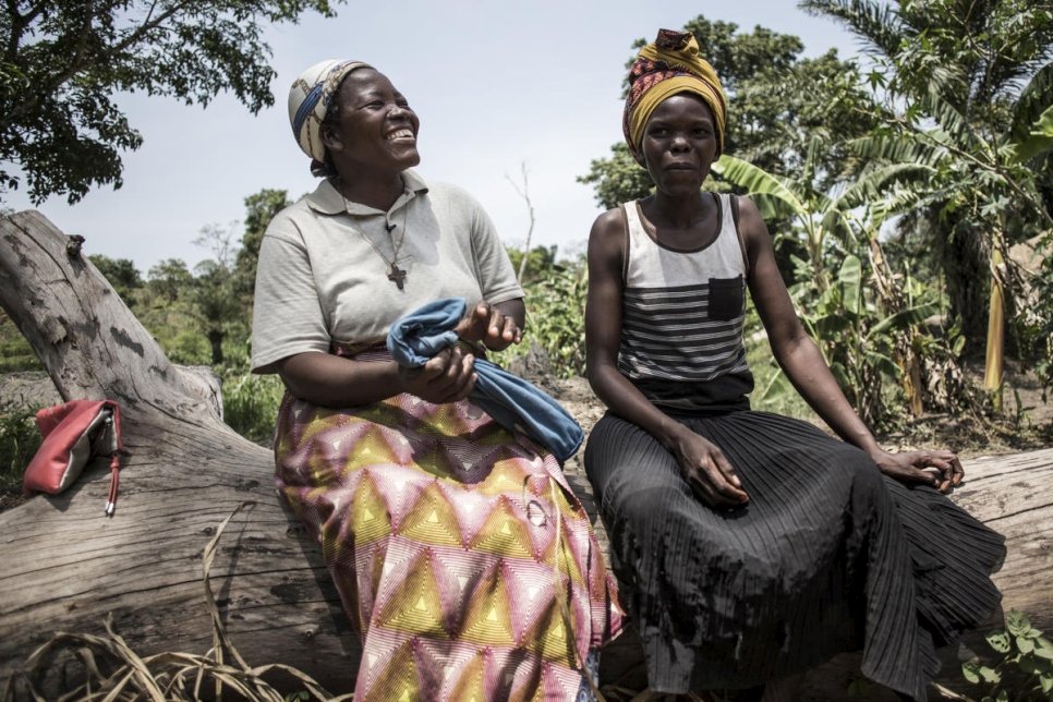 الفائزة السابقة بجائزة نانسن للاجئ، الأخت أنجيليك نامايكا (يسار)، تتحدث مع امرأة تعمل في حقل زراعي في دونغو، جمهورية الكونغو الديمقراطية. 