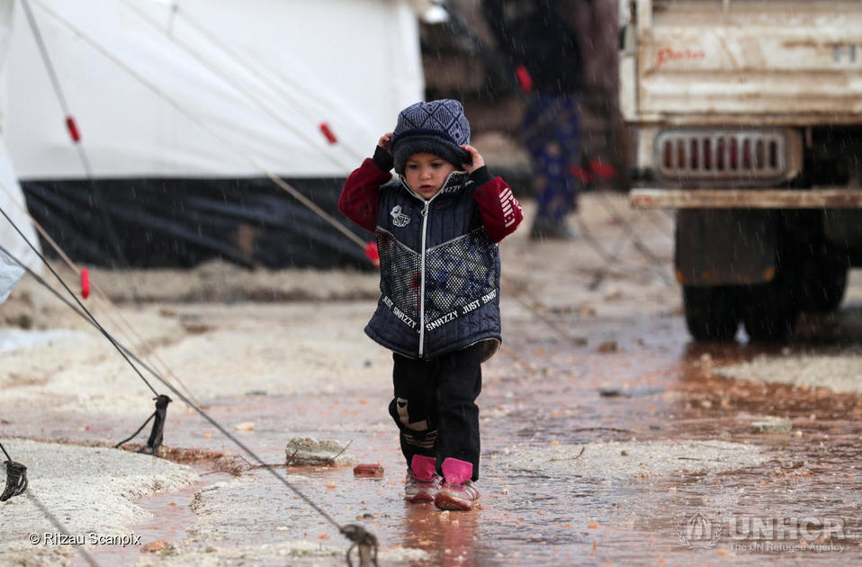 Syria. A displaced Syrian child who fled from southern Idlib walks through the rain in Afrin