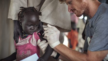 South Sudan / Sudanese Refugees / A doctor working with a UNHCR partner organization provides Dawa Musa's granddaughter, 2 year old Huda Awad, with an inoculation upon arrival from Jamam to Gendrassa refugee camps in Maban County, South Sudan on the 9th of August, 2012. Upon arrival in Gendrassa, all refugees are provided a medical screening. Children are given a series of vaccinations and are examined for malnutrition. Those who are in need of treatment are referred to a UNHCR partner medical organization (both MSF - Medicines Sans Frontiers - and IMC - International Medical Corps were operating in Gendrassa at the time the photograph was taken) for follow up with Plumpynut, a ready to use therapeutic food (RUTF), oral rehydration salts (ORS) or other treatments as necessary. Widespread flooding in Jamam camp moved UHNCR to undertake the task of relocating thousands of refugees approximately 70 kilometers from Jamam to a new site, called Gendrassa, which is less prone to flooding, and better suited to providing for the needs of refugees. ; At the time this photograph was taken, more than 100,000 people had fled conflict in Sudan's Blue Nile State, seeking refuge across the border in South Sudan's Upper Nile State. The topography of Upper Nile is such that the area is prone to extensive flooding. During the rainy season, large potions of northern South Sudan are inundated with water, leading to high levels of malaria and other diseases. Travel in the region is also exceptionally difficult, with roads becoming impassable for months at at time.