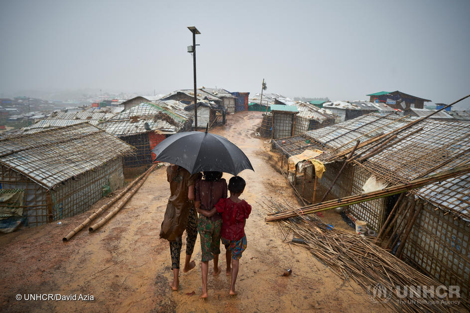 Bangladesh. Rohingya refugees walk through a heavy downpour