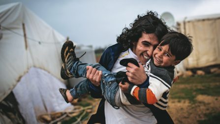 Lebanon / Syrian Refugees / 3 year-old Ashraf, and his brother Hany, pictured outside their family's shelter at an informal tented settlement in the Bekaa Valley, Lebanon, on 12 March 2014. Ashraf was born on 15th March 2011, on the same day that Syria's conflict began. For the first 2 years of his life he grew up under ever-increasingly violence as the conflict escalated into outright civil war. One year ago his family, including his mother and father, 4 brothers and 2 sisters left there home on the outskirts of Homs and fled across the border to Lebanon. They now live in a makeshift shelter just off the main road that leads to Damascus. Ashraf's family speak of a small boy who loves nothing more than to run through the settlement but also of the fear of loud noises and the trauma of the memories he still holds from those days inside Syria. Hany was a talented student in Syria and his most precious possessions now are his high school diplomas. Holding them proudly he says, "These are my life, they are my future. I left everything behind in Syria, but not these." Hany had wanted to go to university to study to be a communications engineer but the war prevented any hope of further education. Competent in English Hany taught himself the language from songs and movies and the internet, he is a keen poet and at recitation in his shelter members of the audience were visibly moved by his words. "Poetry is a part of me," says Hany, "I do it to complete my emotions." With all this potential and passion for the world Hany spends his days in the small shelter with his phone and occasional internet connection as his only means of escape. The monotony burdens him deeply and it is with a heavy sadness that he adds, "I'm wasting a lot of time here, I cannot achieve my dreams." / UNHCR / A. McConnell / March 2014