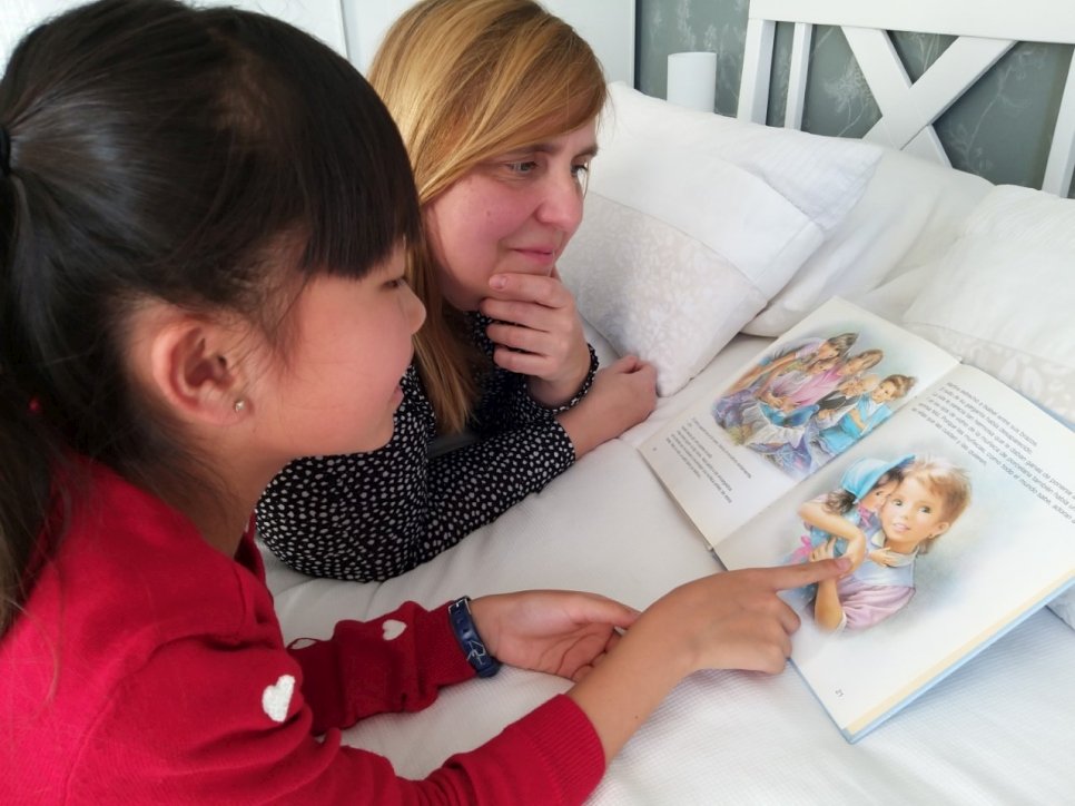 Sonia, 10 ans, et sa Maman, Maripaz, à leur domicile à Madrid, choisissent des contes à enregistrer pour les enfants réfugiés confinés dans des centres de demandeurs d'asile, en raison de la lutte contre la pandémie de Covid-19. 