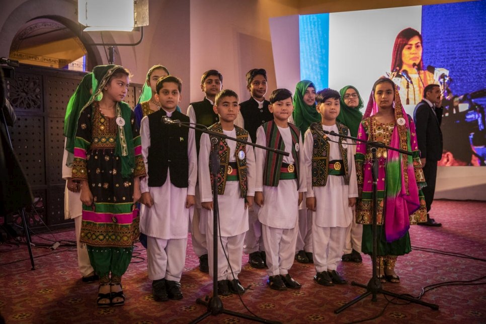 أطفال أفغان وباكستانيون يرتدون ملابس وطنية تقليدية ويغنون النشيد الوطني لكلا البلدين في بداية "قمة اللاجئين" في إسلام أباد. 