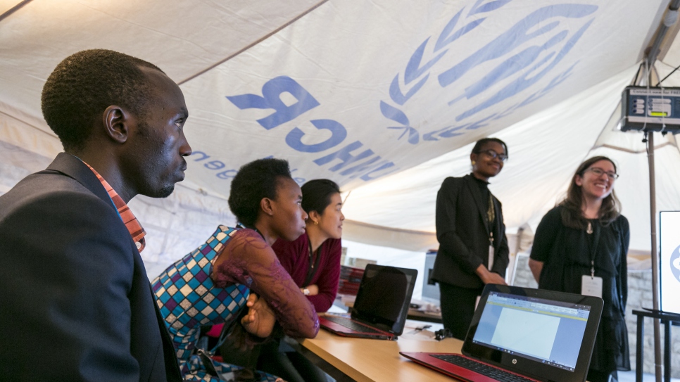 Chelsea Waite (à droite) et Elyse Gainor (deuxième à droite), du Digital Promise Global, présentent leur travail et leurs solutions dans une tente du HCR lors de la Semaine de l'apprentissage mobile 2017 au siège de l'UNESCO à Paris, du 20 au 24 mars 2017.
À gauche, Jonas Havugimana, âgé de 27 ans, est un étudiant congolais en médecine qui est actuellement réfugié au Rwanda. Grace Muvunyi Nshimiyumukiza (deuxième à gauche), une étudiante réfugiée de 21 ans originaire du Rwanda, est née en Tanzanie et réside dans le camp de réfugiés Kakuma au Kenya.