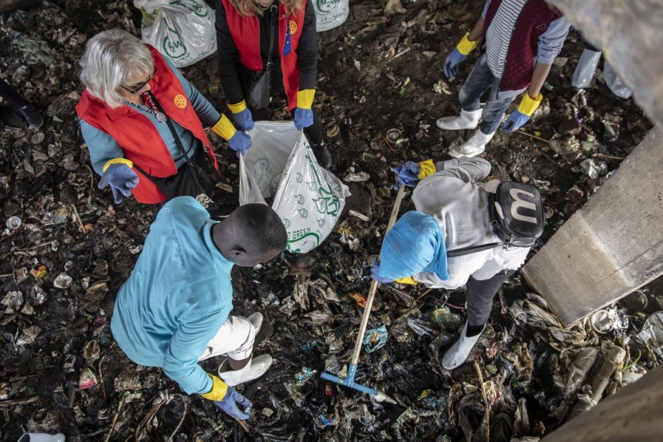 اللاجئان السودانيان عمر (يسار) ومودة (يمين) يضعان النفايات في أكياس.