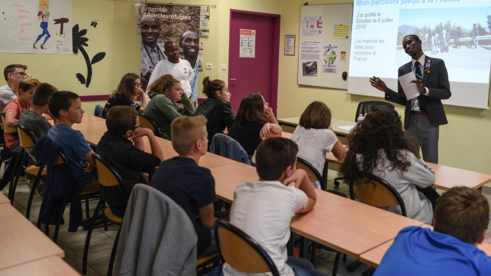 Pupils listen to Sudanese refugee Hassan Mahamat tell the story of his journey to France via Libya and the Mediterranean.