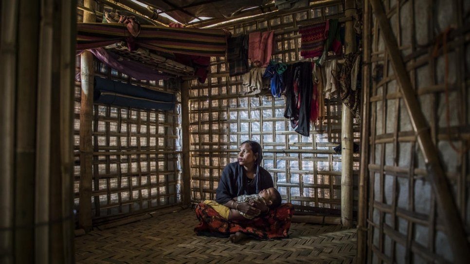 Rahima Khatun holds her son Mohammad Arafat as he sleeps in their shelter in Camp 1 West, Kutupalong, Cox's Bazar, Bangladesh.