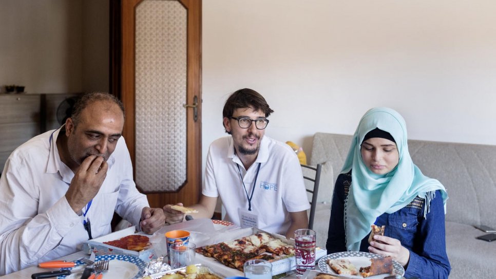Simone Scotta (au centre), de la Fédération italienne des Églises évangéliques, mange une pizza avec Ammar Issa, 48 ans, et Sara, 16 ans, des réfugiés palestiniens syriens nouvellement arrivés à Rome depuis le Liban. 