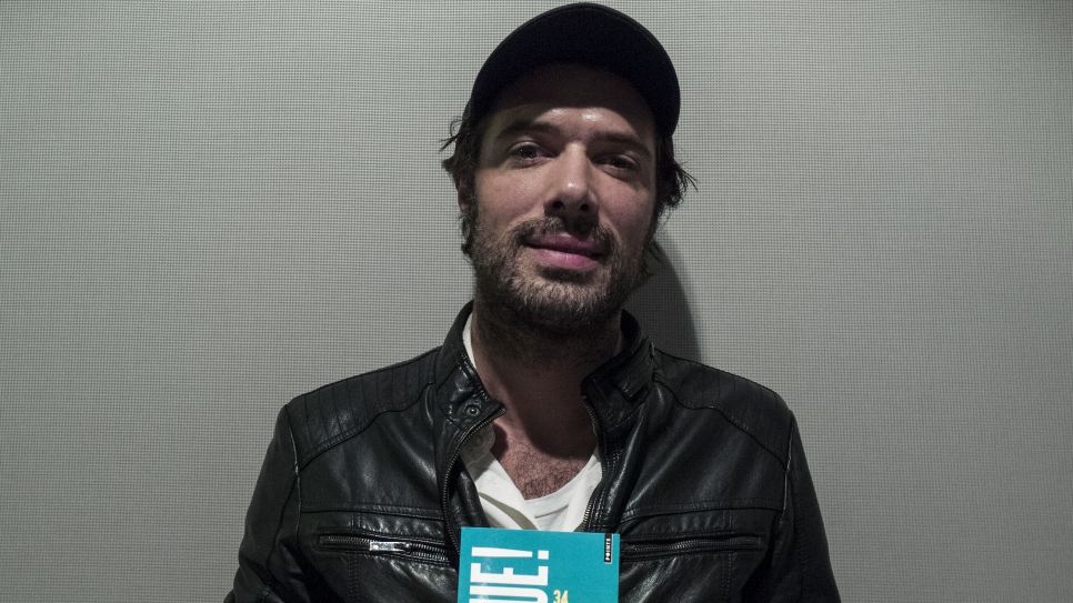 L'acteur français, Nicolas Bedos, pose avec le livre "Bienvenue!", dans lequel il a écrit la nouvelle "Embarcation de fortune", lors de son lancement à la Bibliothèque nationale François Mitterrand à Paris, le 3 décembre 2015. 