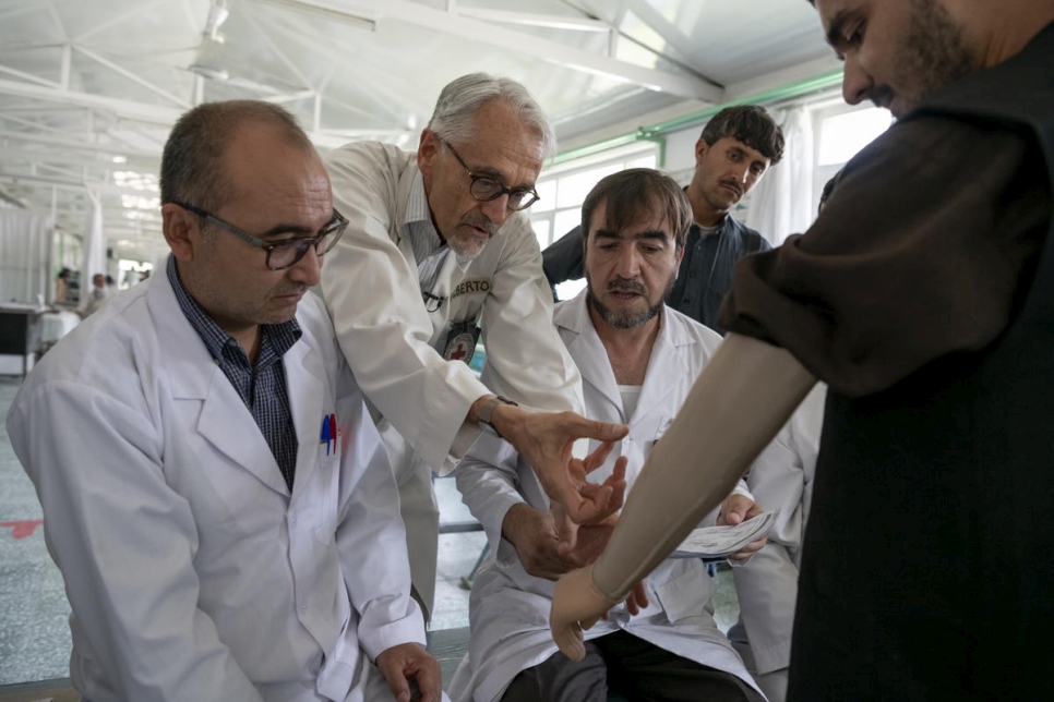 يعالج أخصائي العلاج الطبيعي الإيطالي ألبيرتو كايرو (وسط) أحد المرضى مع فريقه في مركز إعادة التأهيل البدني في كابول، أفغانستان.
