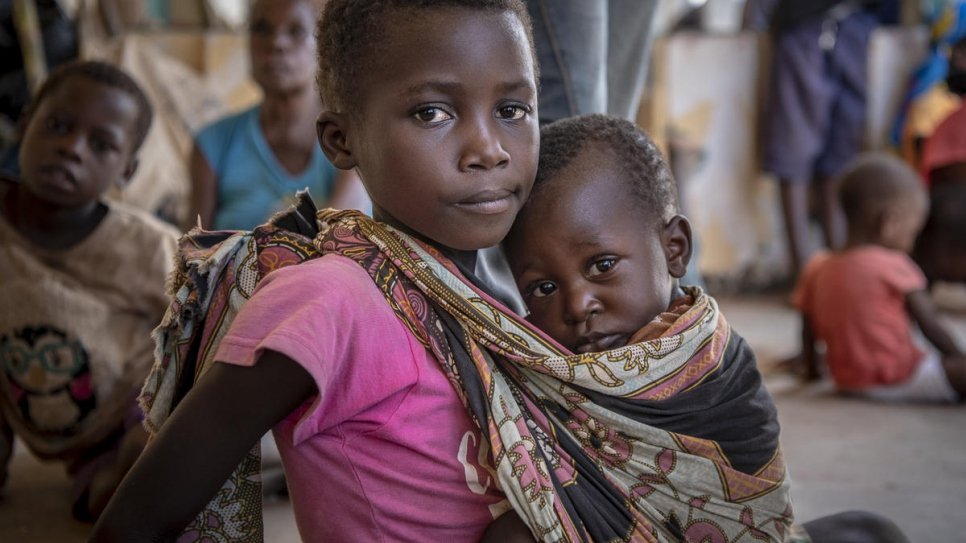 Seven-year-old Rosa holds her younger brother, Manuel, at a shelter for women and children displaced by Cyclone Idai in Buzi, Mozambique. 