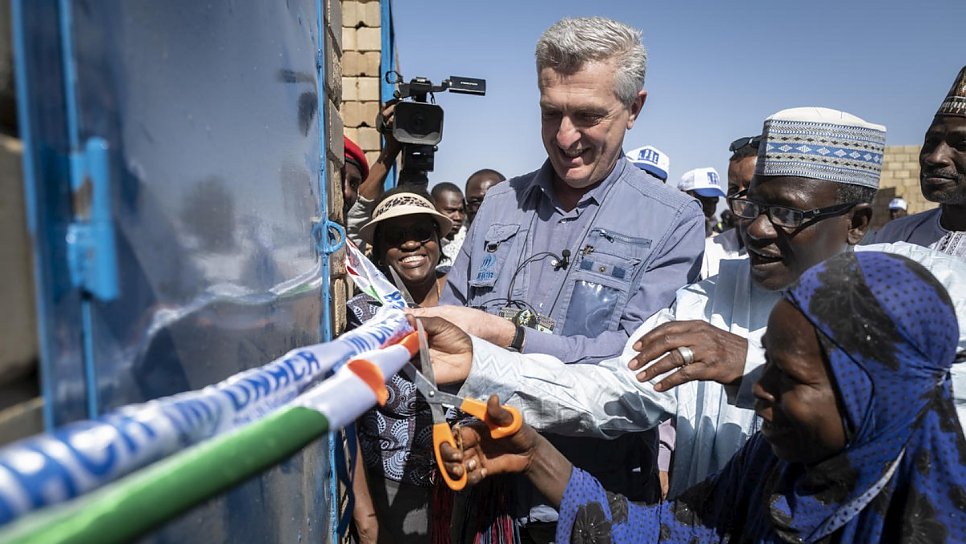 Le Haut Commissaire des Nations Unies pour les réfugiés, Filippo Grandi, coupe le ruban aux côtés d'Aminatou Chekaraou, premier membre de la communauté d'accueil à recevoir une maison en briques à Ouallam. 