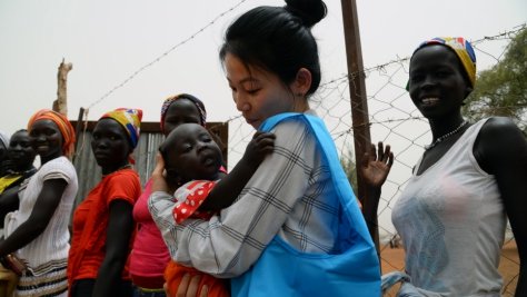 Eujin Byun, employée du HCR, tient un bébé réfugié dans les bras dans un camp de réfugiés au Soudan du Sud. 