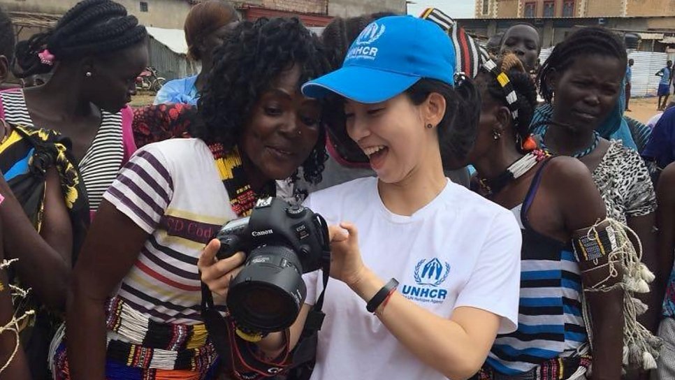 UNHCR communications officer Eujin Byun shows pictures to women at a refugee camp in South Sudan.