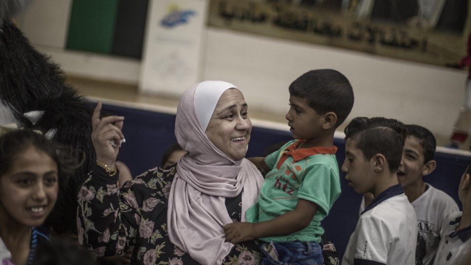 Abir Khreisha joue avec un enfant réfugié syrien dans un centre communautaire à Madaba, en Jordanie. 