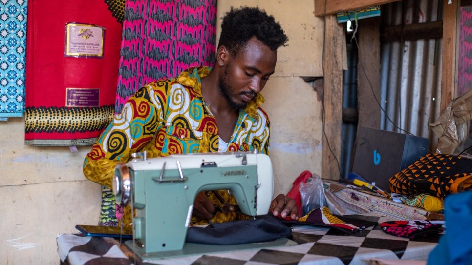 Refugee tailor Maombi Samil makes facemasks at his shop in Kenya's Kakuma camp. His is one of the many refugee-run businesses helping to fight COVID-19.