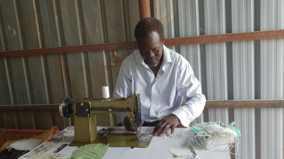 Peter Oman, a South Sudanese tailor, makes masks in Al Redis 2 camp, White Nile State, Sudan.