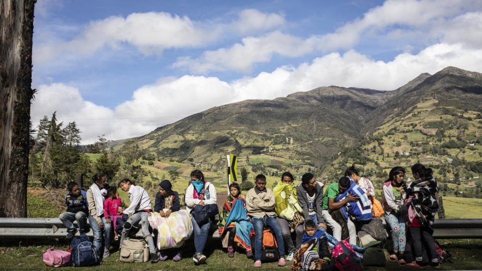 Une famille de 17 personnes qui marchent depuis cinq jours. Assis au soleil pour se réchauffer, ils ont quitté leur abri au petit matin pour poursuivre la route jusqu'à la ville colombienne de Pamplona. 